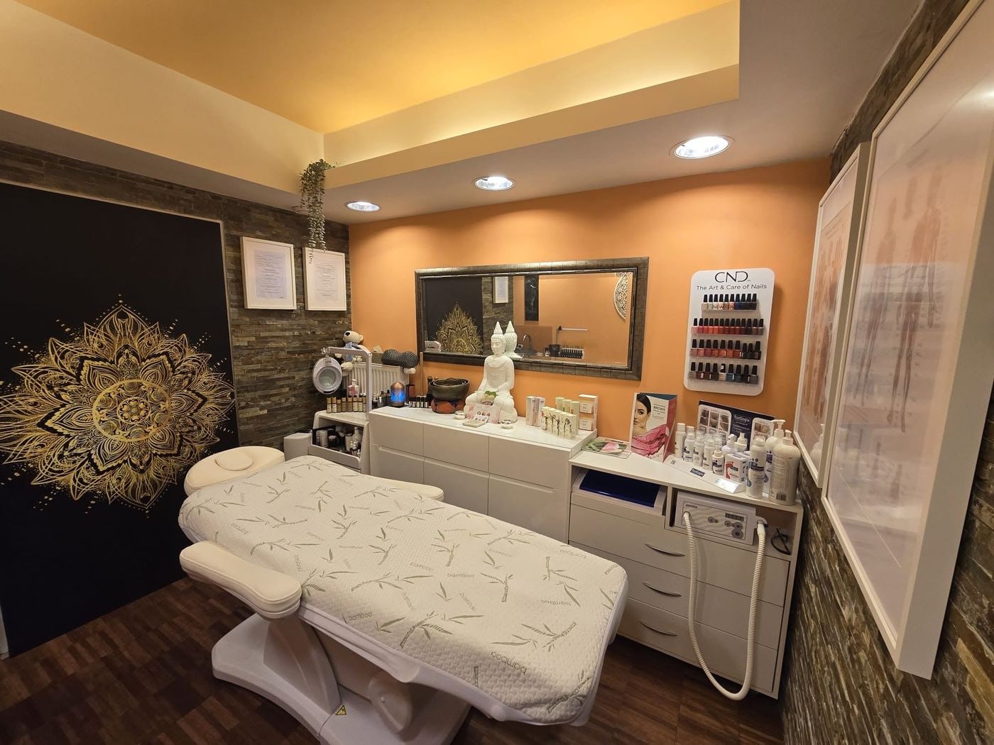 Treatment room of the Hotel Vista salon – bed, golden mandala and products, Brno